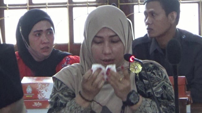 Laras Risna Hastutik Guru SD Negeri 03 Getas, Kecamatan Wonosalam, Kabupaten Demak, menangis mengadukan nasib ke DPRD Demak, Senin (13/1/2025). (suara.com/Sigit AF)