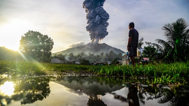 Seorang warga melihat erupsi dari kawah Gunung Ibu terlihat dari Desa Duono, Kabupaten Halmahera Barat, Maluku Utara, Rabu (15/1/2024). [ANTARA FOTO/Andri Saputra/foc]