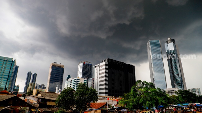 Penampakan awan mendung yang menyelimuti permukiman dan gedung bertingkat di Jakarta, Senin (20/1/2025). [Suara.com/Alfian Winanto]