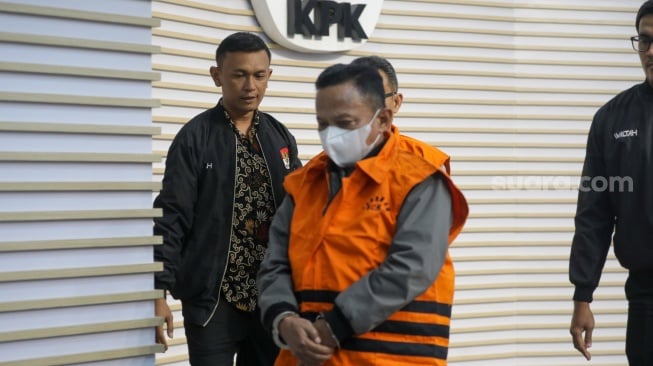 Petugas menggiring Bupati Situbondo nonaktif Karna Suswandi usai menjalani pemeriksaan di Gedung Merah Putih KPK, Jakarta, Selasa (21/1/2025). [Suara.com/Alfian Winanto]