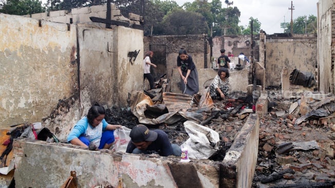 Warga mengambil barang sisa kebakaran di pemukiman padat penduduk, kawasan Kemayoran, Jakarta, Selasa (21/1/2025). [Suara.com/Alfian Winanto]