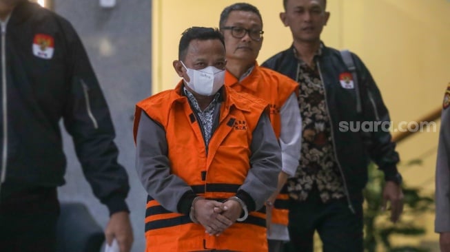 Petugas menggiring Bupati Situbondo nonaktif Karna Suswandi usai menjalani pemeriksaan di Gedung Merah Putih KPK, Jakarta, Selasa (21/1/2025). [Suara.com/Alfian Winanto]