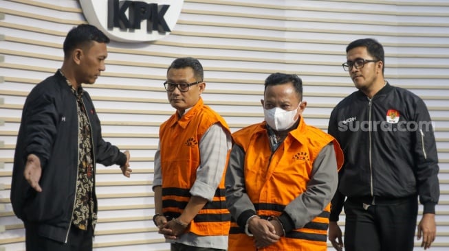 Petugas menggiring Bupati Situbondo nonaktif Karna Suswandi usai menjalani pemeriksaan di Gedung Merah Putih KPK, Jakarta, Selasa (21/1/2025). [Suara.com/Alfian Winanto]