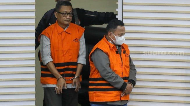 Petugas menggiring Bupati Situbondo nonaktif Karna Suswandi usai menjalani pemeriksaan di Gedung Merah Putih KPK, Jakarta, Selasa (21/1/2025). [Suara.com/Alfian Winanto]