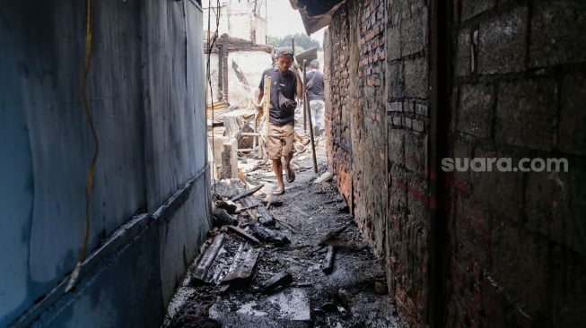 Warga mengambil barang sisa kebakaran di pemukiman padat penduduk, kawasan Kemayoran, Jakarta, Selasa (21/1/2025). [Suara.com/Alfian Winanto]