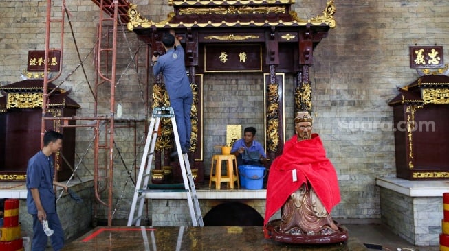 Warga keturunan Tionghoa membersihkan area ibadah di Vihara Amurva Bhumi, Jakarta, Rabu (22/1/2025). [Suara.com/Alfian Winanto]