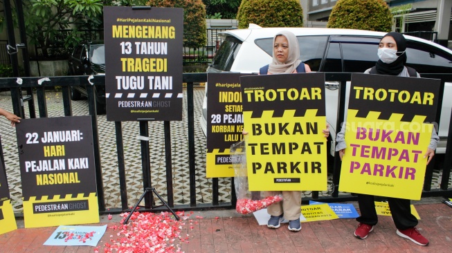 Aktivis dari Koalisi Pejalan Kaki menggelar aksi di Halte Tugu Tani, Jakarta, Rabu (22/1/2025). [Suara.com/Alfian Winanto