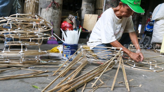 Perajin membuat replika barang-barang untuk sembahyang yang terbuat dari kertas di Kolong Tol Gedong Panjang, Jakarta, Kamis (23/1/2025). [Suara.com/Alfian Winanto]