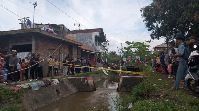 Lokasi penemuan mayat bayi di Sungai Cikunten, Kecamatan Kawalu, Tasikmalaya dipasang garis polisi. Foto: Apip/HR