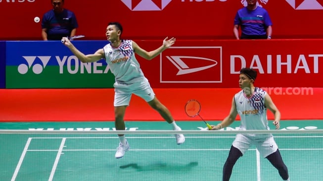 Pebulu Tangkis Ganda Putra Indonesia, Fajar Alfian dan Muhammad Rian Ardianto saat melawan Pebulu Tangkis Ganda Putra Malaysia Man Wei Chong dan Kai Wun Tee menunjukan medali dan piala usai pertandingan final Daihatsu Indonesia Masters 2025 di Istora Senayan, Jakarta, Minggu (26/1/2025). [Suara.com/Alfian Winanto]