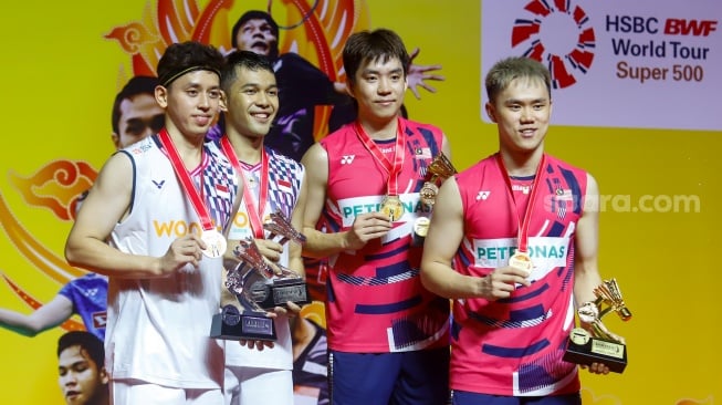 Pebulu Tangkis Ganda Putra Indonesia, Fajar Alfian dan Muhammad Rian Ardianto bersama Pebulu Tangkis Ganda Putra Malaysia Man Wei Chong dan Kai Wun Tee menunjukan medali dan piala usai pertandingan final Daihatsu Indonesia Masters 2025 di Istora Senayan, Jakarta, Minggu (26/1/2025). [Suara.com/Alfian Winanto]
