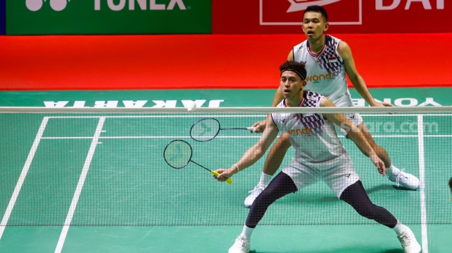 Pebulu Tangkis Ganda Putra Indonesia, Fajar Alfian dan Muhammad Rian Ardianto saat melawan Pebulu Tangkis Ganda Putra Malaysia Man Wei Chong dan Kai Wun Tee menunjukan medali dan piala usai pertandingan final Daihatsu Indonesia Masters 2025 di Istora Senayan, Jakarta, Minggu (26/1/2025). [Suara.com/Alfian Winanto]