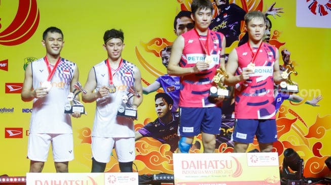 Pebulu Tangkis Ganda Putra Indonesia, Fajar Alfian dan Muhammad Rian Ardianto bersama Pebulu Tangkis Ganda Putra Malaysia Man Wei Chong dan Kai Wun Tee menunjukan medali dan piala usai pertandingan final Daihatsu Indonesia Masters 2025 di Istora Senayan, Jakarta, Minggu (26/1/2025). [Suara.com/Alfian Winanto]
