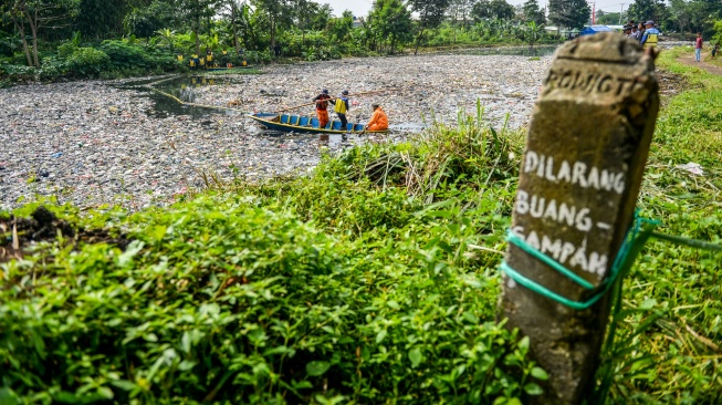 Petugas kebersihan mengambil sampah yang menumpuk di Sungai Citarum Lama, di Cicukang, Margaasih, Kabupaten Bandung, Jawa Barat, Senin (27/1/2025). [ANTARA FOTO/Raisan Al Farisi/foc]