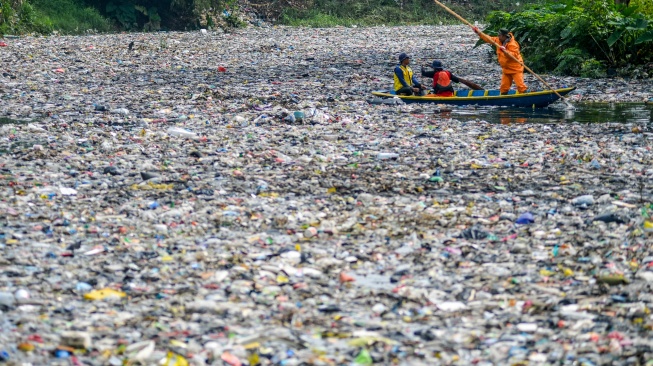 Petugas kebersihan mengambil sampah yang menumpuk di Sungai Citarum Lama, di Cicukang, Margaasih, Kabupaten Bandung, Jawa Barat, Senin (27/1/2025). [ANTARA FOTO/Raisan Al Farisi/foc]