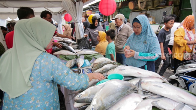 Pembeli memilih ikan dalam acara Festival Bandeng Rawa Belong di Jakarta, Senin (27/1/2025). [Suara.com/Alfian Winanto]