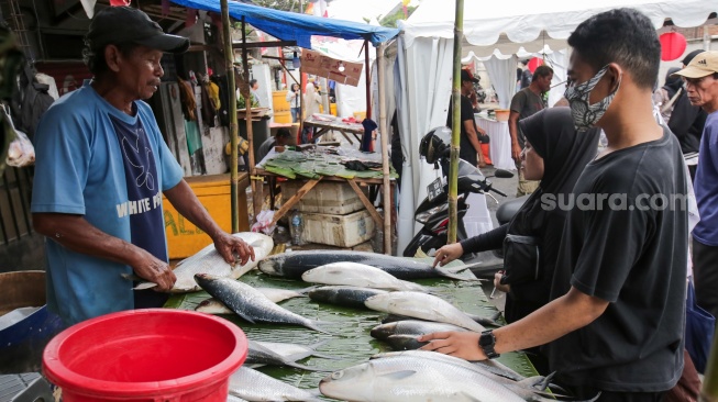 Pembeli memilih ikan dalam acara Festival Bandeng Rawa Belong di Jakarta, Senin (27/1/2025). [Suara.com/Alfian Winanto]