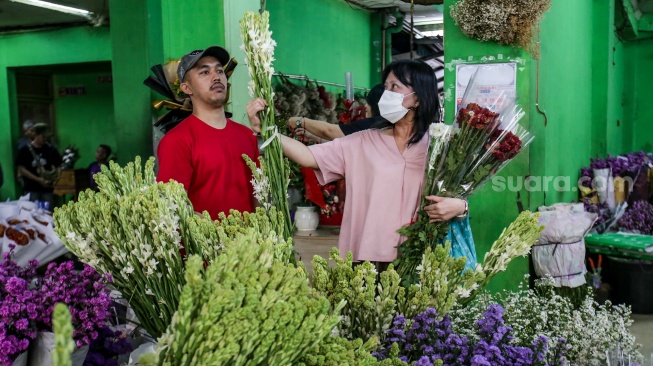 Pengunjung memilih bunga sedap malam di Pasar Bunga Rawa Belong, Jakarta, Selasa (28/1/2025). [Suara.com/Alfian Winanto]