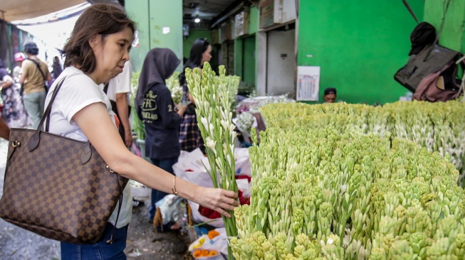 Pengunjung memilih bunga sedap malam di Pasar Bunga Rawa Belong, Jakarta, Selasa (28/1/2025). [Suara.com/Alfian Winanto]