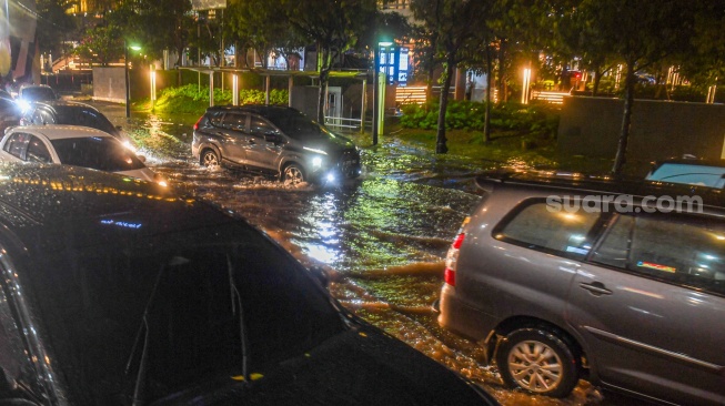 Sejumlah kendaraan melintasi genangan di kawasan Sarinah Thamrin, Jakarta, Selasa (28/1/2025). [ANTARA FOTO/Muhammad Adimaja/foc]