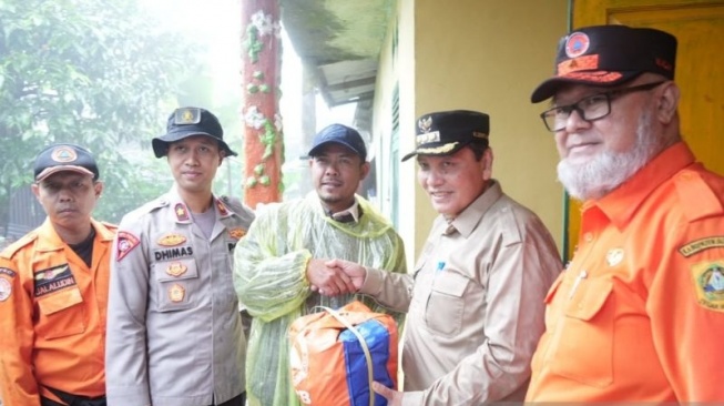 Penjabat Bupati Bogor Bachril Bakri memberikan bantuan kepada korban bencana banjir bandang di Desa Tugu Selatan, Kabupaten Bogor, Jawa Barat, Rabu (29/1/2025). (ANTARA/HO-Humas Pemkab Bogor)