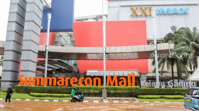 Pengendara melintasi banjir di Jalan Boulevard Raya, Kelapa Gading, Jakarta, Rabu (29/1/2025). [Suara.com/Alfian Winanto]