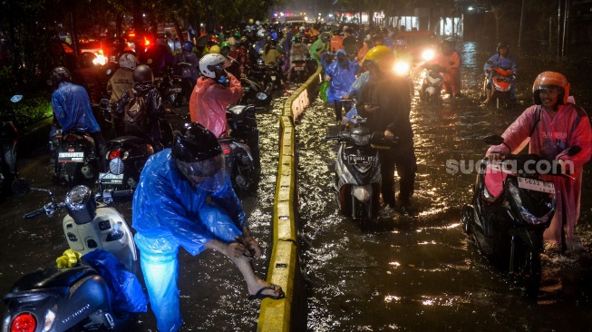 Sejumlah pengendara motor menuntun motornya melewati banjir di Jalan Daan Mogot, Cengkareng, Jakarta, Selasa (28/1/2025). [ANTARA FOTO/Putra M. Akbar/gp/foc]