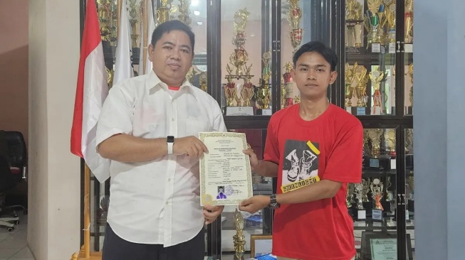 Kepala SMK Jamiyyatul Aulad Palabuhanratu Sukabumi, Andriana (kiri), saat menyerahkan ijazah gratis kepada siswanya, Kamis (30/1/2025). Hal itu sesuai permintaan Dedi Mulyadi. (Sumber Foto: Istimewa)