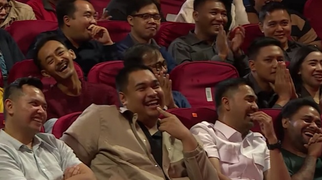 Menpora RI Dito Ariotedjo tertawa saat komika Fajar Mukti membahas Mulyono dan Fufufafa. (YouTube Stand Up Kompas TV)