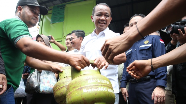 Menteri Energi dan Sumber Daya Mineral (ESDM) Bahlil Lahadalia (tengah) membantu melayani warga yang mengantre membeli gas elpiji 3 kilogram saat melakukan pemantauan di Karawaci, Tangerang, Banten, Selasa (4/1/2025). [ANTARA FOTO/Muhammad Iqbal/YU]