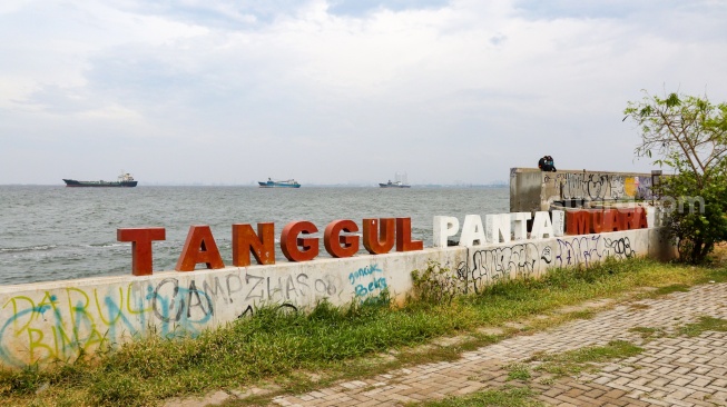 Warga beraktivitas di sekitar tanggul laut kawasan muara baru, Jakarta, Rabu (5/2/2025). [Suara.com/Alfian Winanto]