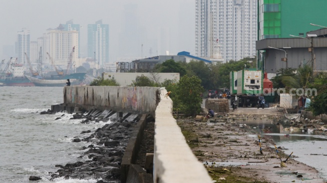 Warga beraktivitas di sekitar tanggul laut kawasan muara baru, Jakarta, Rabu (5/2/2025). [Suara.com/Alfian Winanto]