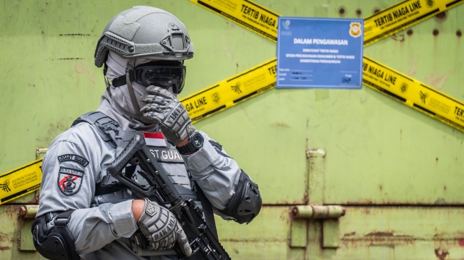 Petugas Badan Keamanan Laut (Bakamla) berjaga di depan barang bukti truk membawa pakaian bekas saat ekspose hasil pengawasan oleh Kementerian Perdagangan dan Bakamla di Jakarta, Rabu (5/2/2025). [ANTARA FOTO/Bayu Pratama S/rwa]