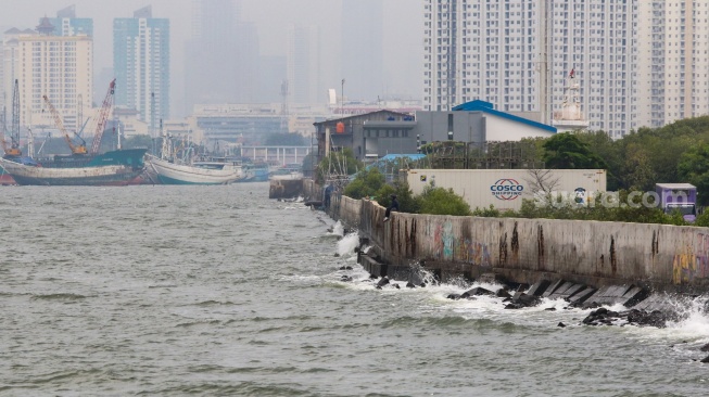 Warga beraktivitas di sekitar tanggul laut kawasan muara baru, Jakarta, Rabu (5/2/2025). [Suara.com/Alfian Winanto]