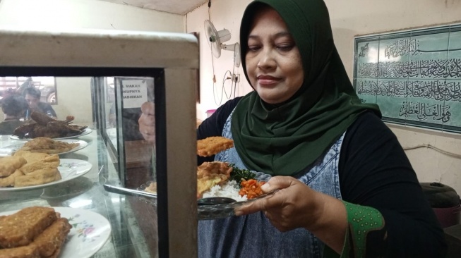 Tuti, seorang pedagang nasi di Palmera, Jakarta Barat (Suara.com/Faqih Fathurra)