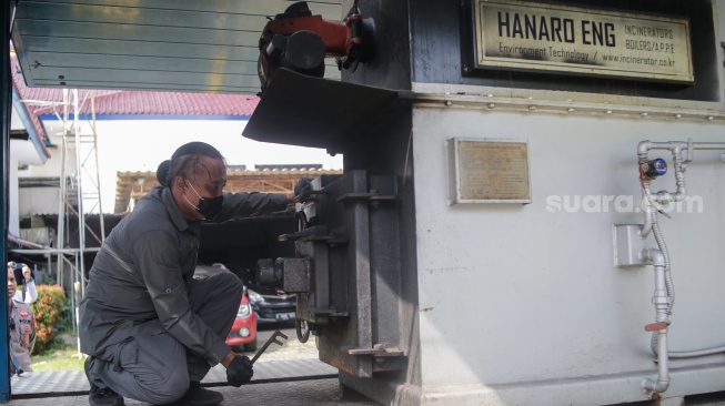 Petugas menaruh narkotika ke dalan mesin penghancur saat pemusnahan barang bukti narkotika di Kantor BNN, Jakarta, Jumat (7/2/2025).  [Suara.com/Alfian Winanto]