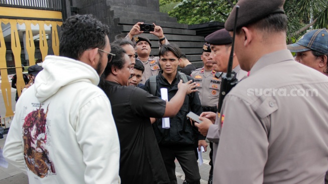 Perwakilan nassa dari Aliansi Rakyat Menggugat (ARM) menemui polisi saat menggelar aksi unjuk rasa di depan Polda Metro Jaya, Jakarta, Jumat (7/2/2025). [Suara.com/Alfian Winanto]