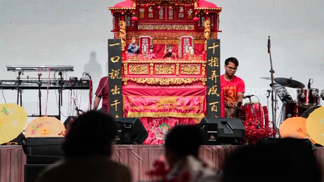 Warga melihat pertunjukan wayang potehi di kawasan Sudirman Central Business District (SCBD), Jakarta, Sabtu (8/2/2025). [Suara.com/Alfian Winanto]