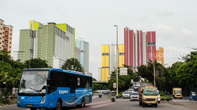 Sejumlah kendaraan melintas di dekat Wisma Atlet Kemayoran, Jakarta, Selasa (11/2/2025). [Suara.com/Alfian Winanto]