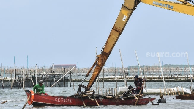 Sejumlah pekerja dari PT TRPN mengangkut bambu pagar laut menggunakan perahu usai pembongkaran di pesisir laut Tarumajaya, Kabupaten Bekasi, Jawa Barat, Selasa (11/2/2025). [ANTARA FOTO/Fakhri Hermansyah/rwa]