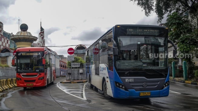 Bus Transjakarta melintas di Terminal Blok M, Jakarta, Rabu (12/2/2025). [Suara.com/Alfian Winanto]