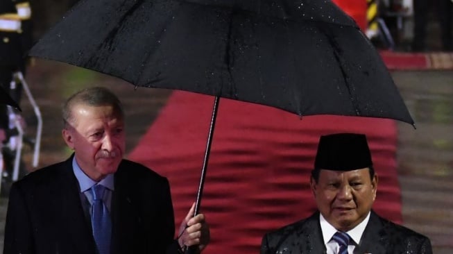 Momen Presiden Turki Recep Tayyip Erdogan saat memayungi Presiden RI, Prabowo Subianto. Momen itu terjadi saat Prabowo menyambut kunjungan Erdogan ke Indonesia. (Antara)