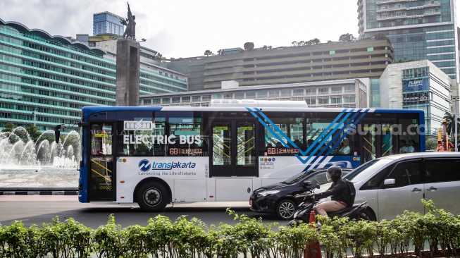 Bus Transjakarta melintas di Kawasan Bundaran HI, Jakarta, Rabu (12/2/2025). [Suara.com/Alfian Winanto]