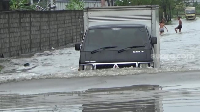 Kendaraan menerjang banjir di Jalan Raya Muktiharjo, Senin (3/2/2025). [suara.com/Sigit AF]