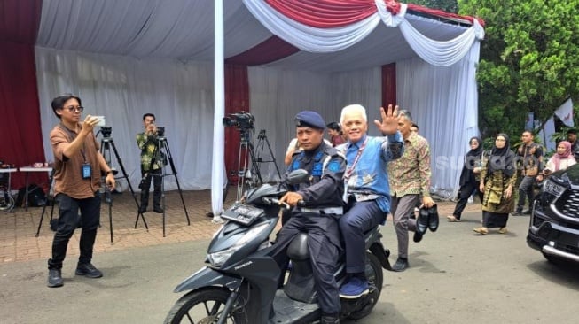 Ketua Majelis Penasihat PAN Hatta Rajasa menaiki sepeda motor saat menghadiri acara Silaturahmi KIM di kediaman Presiden Prabowo, Hambalang, Bogor. (Suara.com/Novian)