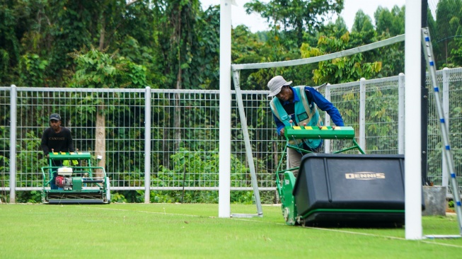 Dua pekerja melakukan perawatan rumput lapangan di Training Center PSSI di Ibu Kota Nusantara (IKN), Penajam Paser Utara, Kalimantan Timur, Jumat (14/2/2025). [ANTARA FOTO/Aditya Nugroho/mrh/tom]