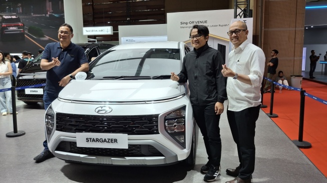 COO PT HMID Fransiscus Soerjopranoto (kiri), CMO PT HMID Budi Nur Mukmin dan CSO PT HMID Moch Diky Zulkarnaen berfoto bersama Hyundai Stargazer Essential Tech di IIMS 2025, Jumat (14/2/2025). [Suara.com/Michele Alessandra Amabelle]