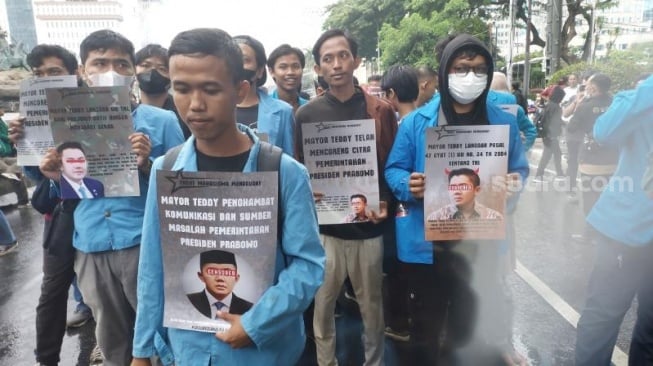 Massa Mahasiswa turut menenteng sejumlah poster protes bergambang Seskab Mayor Teddy Indra Wijaya. (Suara.com/Moh Reynaldi Risahondua)