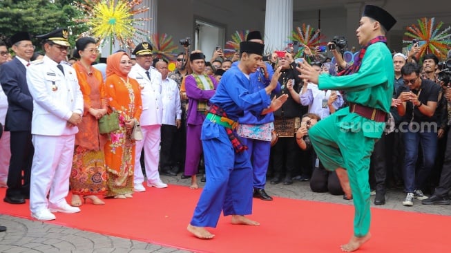 Gubernur dan Wakil Gubernur Jakarta Pramono Anung dan Rano Karno melihat kesenian palang pintu saat tiba di Balai Kota untuk melakukan Serah Terima Jabatan di Jakarta, Kamis (20/2/2025). [Suara.com/Alfian Winanto]