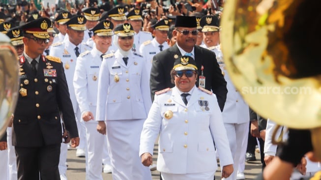 Ratusan kepala daerah terpilih dari gubernur, wali kota dan bupati berjalan beriringan dari Monumen Nasional menuju Istana Merdeka, Jakarta, Kamis (20/2/2025). [Suara.com/Alfian Winanto]